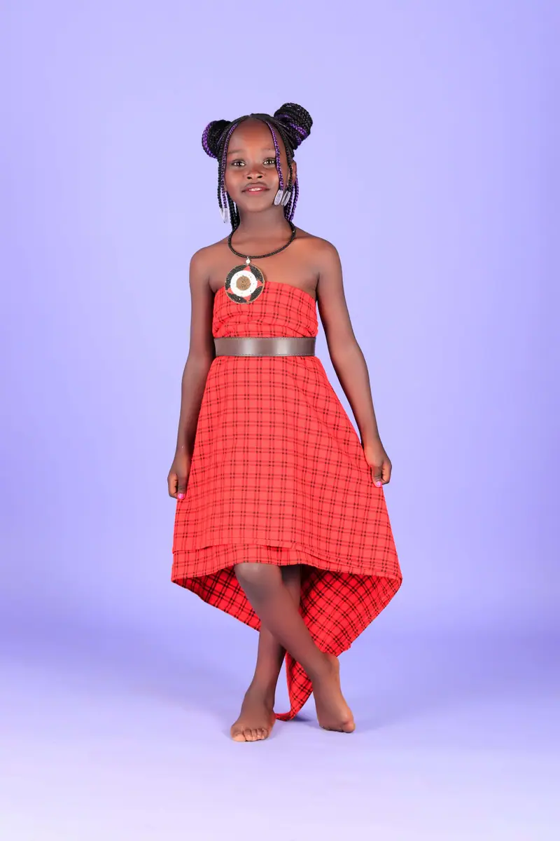Young girl in a red checked dress posing for a kids fashion portrait