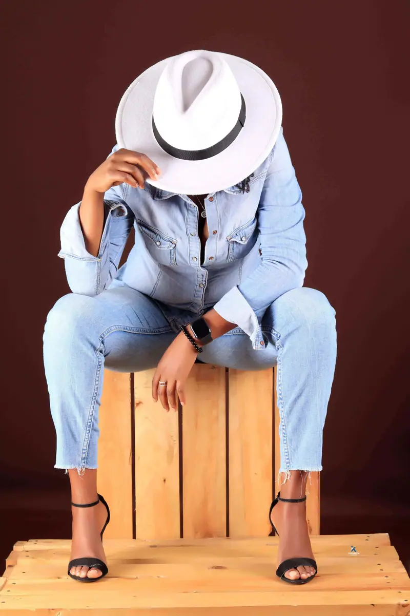 Fashion studio portrait of a woman in denim and a white hat